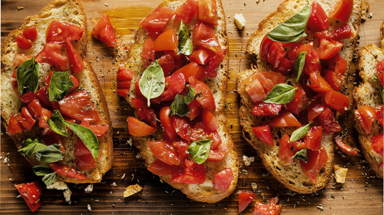 Three pieces of Italian bruschetta bread with tomatoes and basil on them