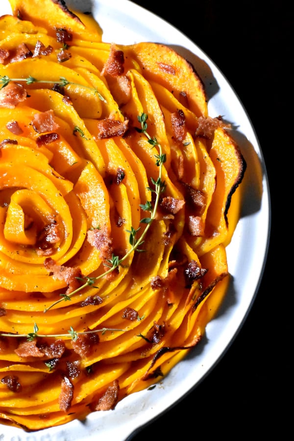 butternut squash blossom in a round white dish against a black background
