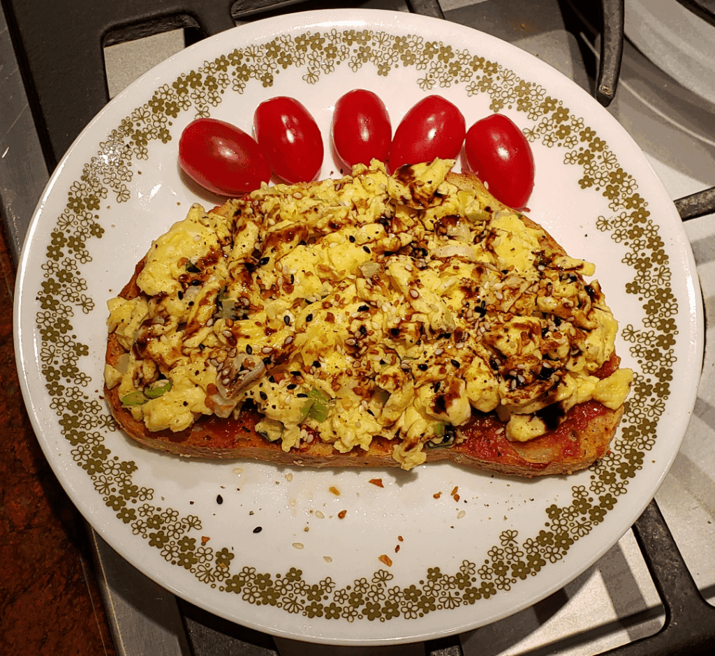 Soft Scramble with Green Onions on Rosemary with Homemade Tomato Jam on Rosemary Sourdough Toast, Everything Bagle Seasoning, and Drizzle of Fig Balsamic