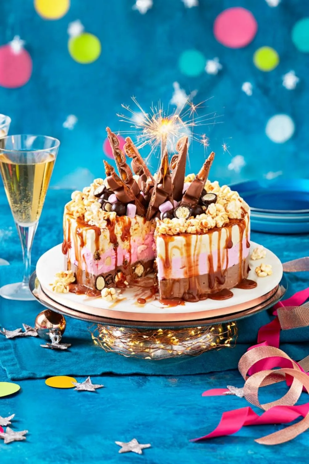 choco-caramel popcorn ice cream cake with lit sparkler in it and dripping caramel dessert recipes