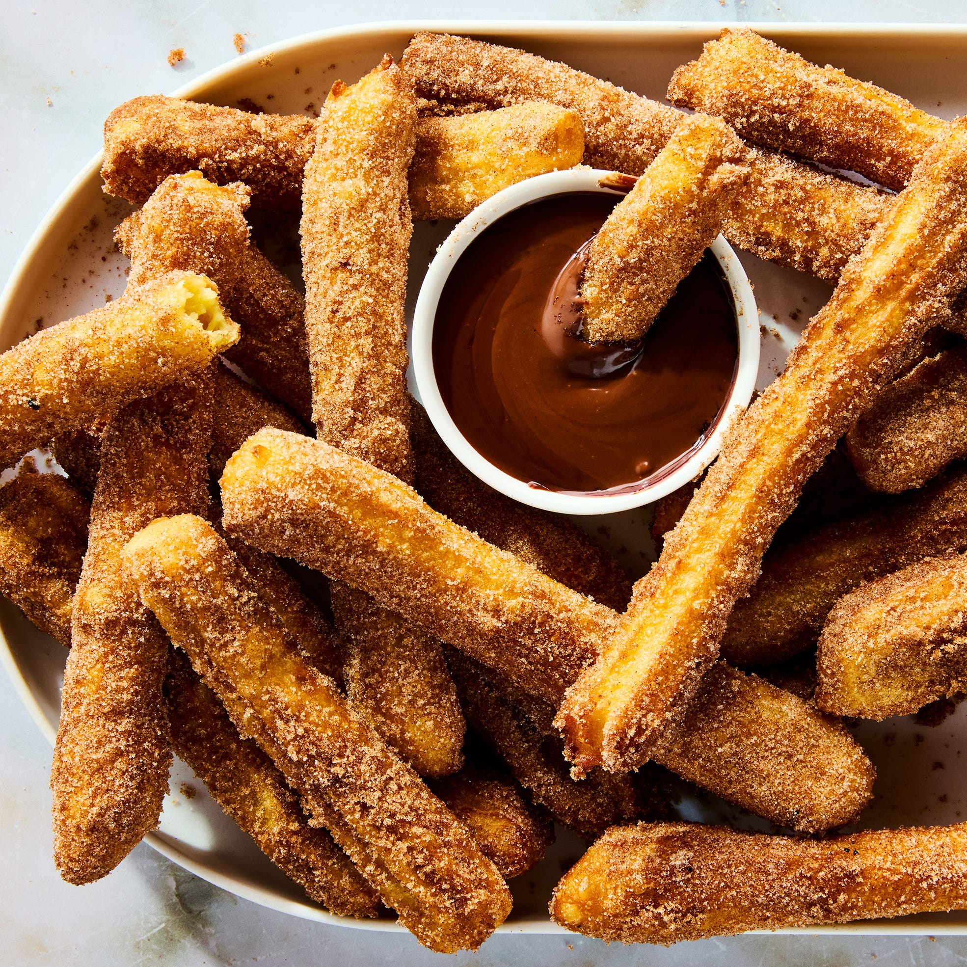 churros on a platter with chocolate dipping sauce