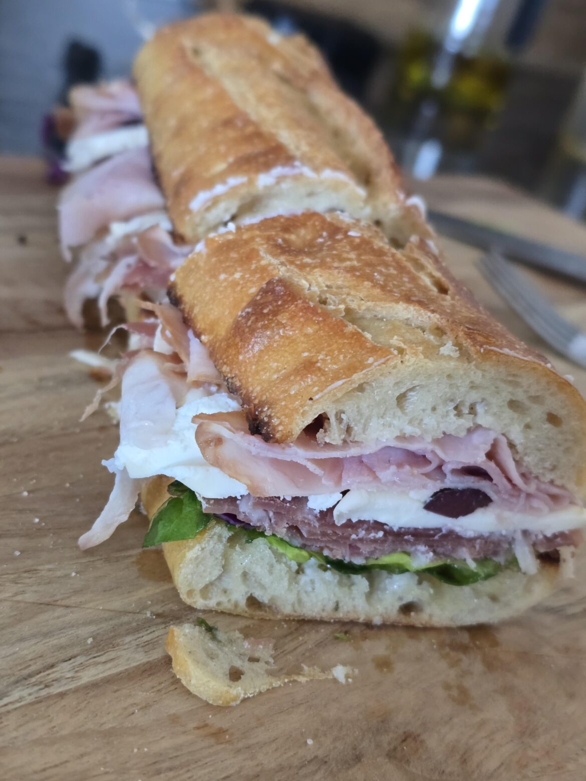 Baguette with black forest ham, fresh mozz, Greek olives, prosciutto, lettuce, and 'erbs