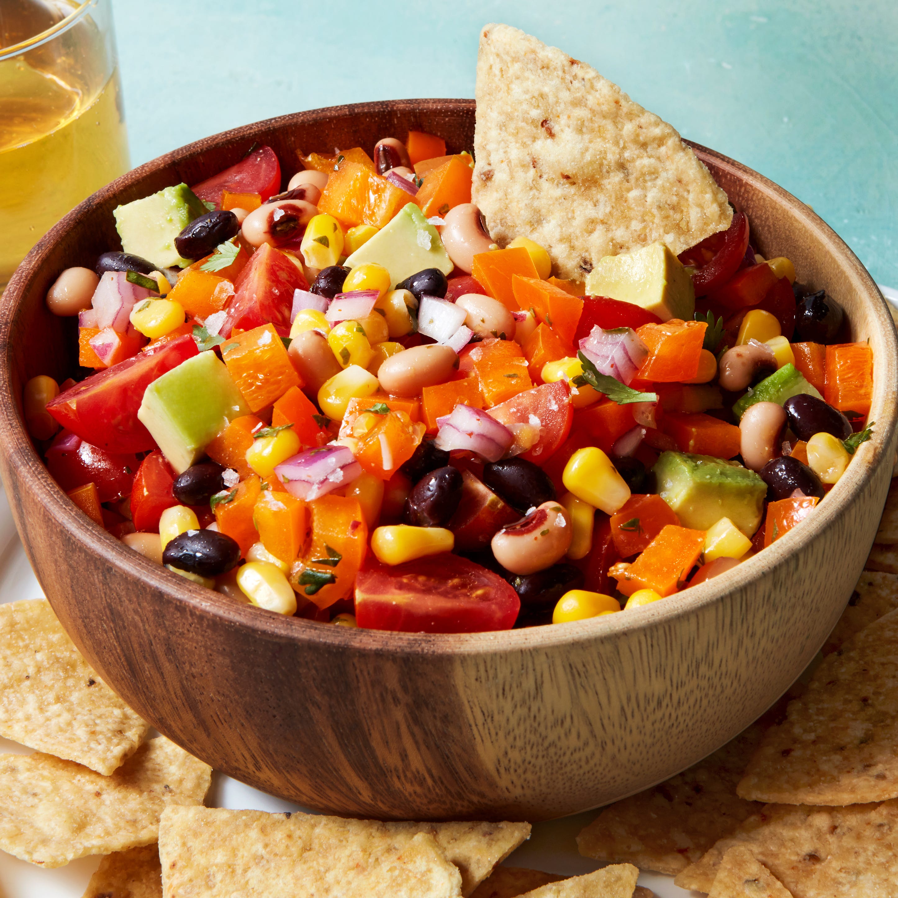 beans, tomatoes, red onion, and avocado in a bowl with chips