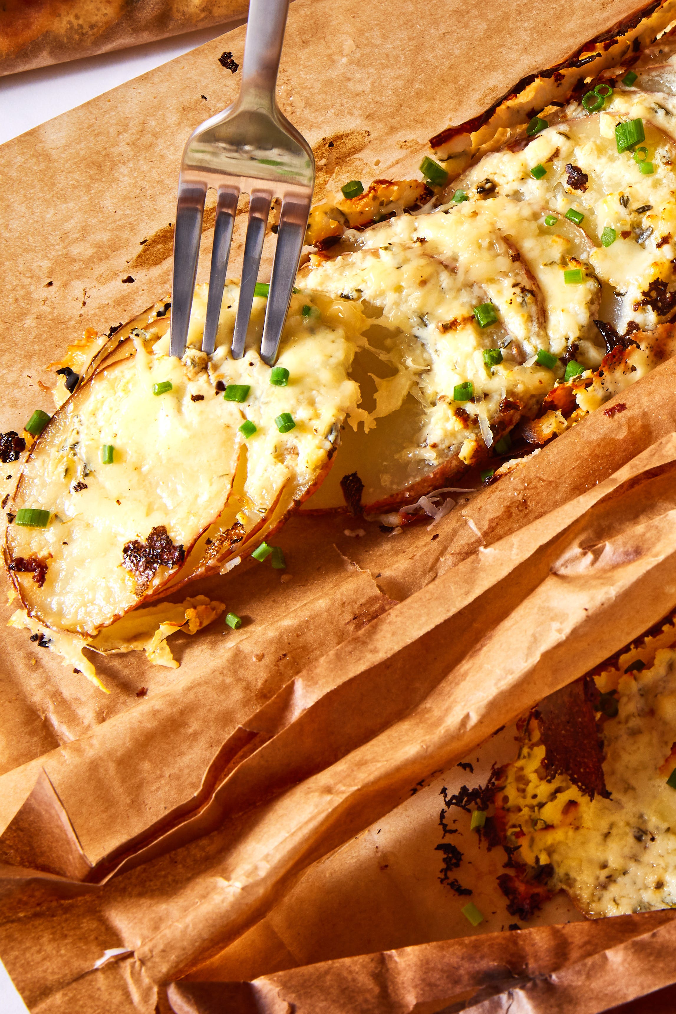 thinly sliced red potatoes layered with herby cream cheese, parmesan, and gruyere and baked in a parchment pouch
