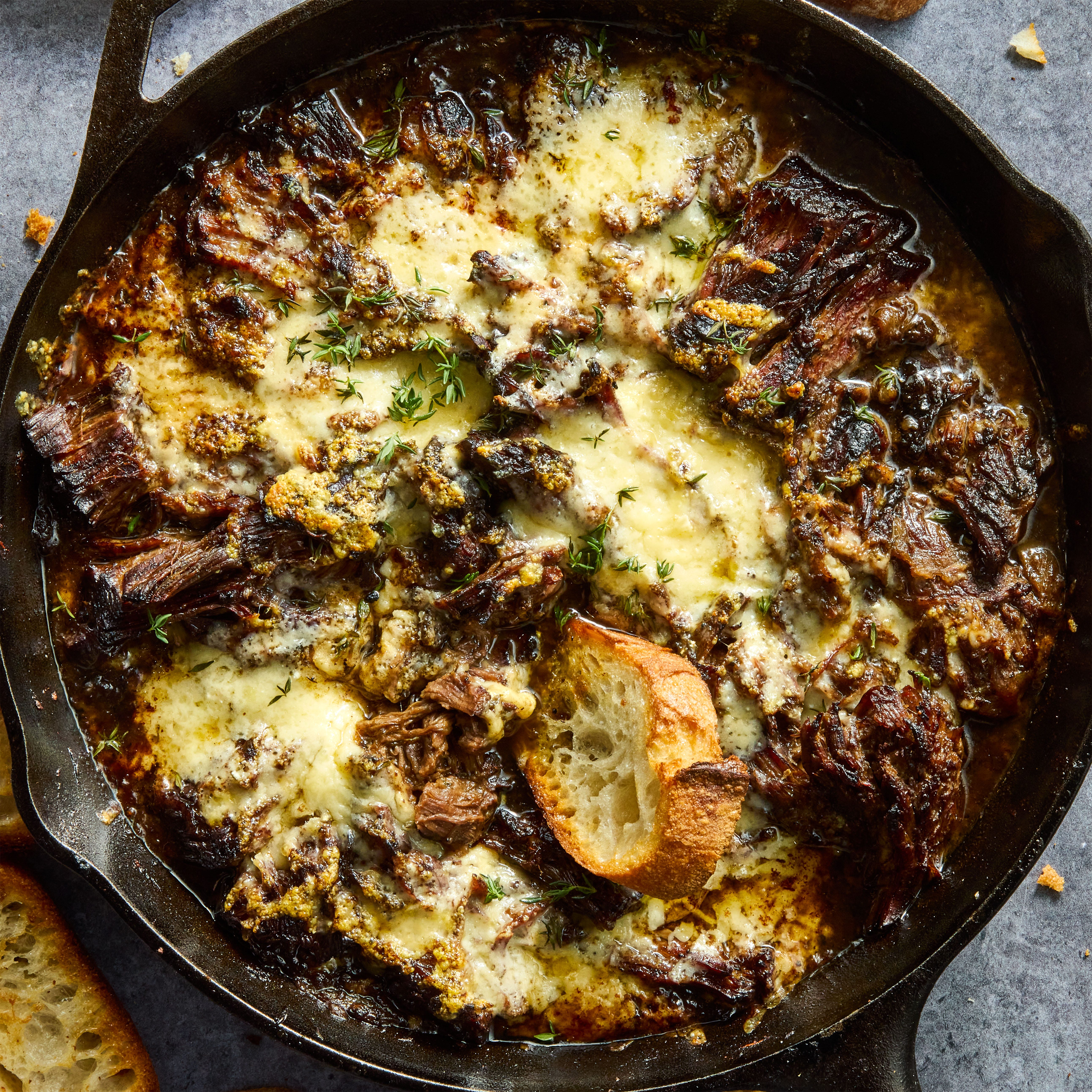 onion seasoned beef is nestled in a bed of cooked onions, red wine, fresh thyme, and beef broth, then braised until ridiculously tender, shredded, and topped with nutty, salty gruyere cheese