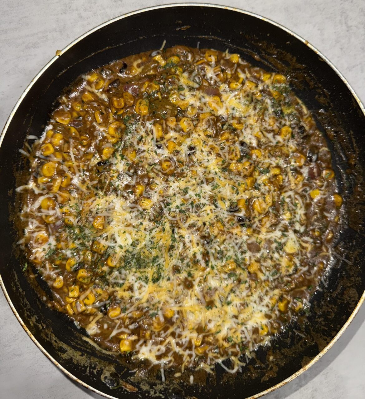 Much needed fridge clean out. Corn, tad bit of cream corn, black beans, tomatoes, red onion, pickled jalapeños, cilantro, seasonings of choice, mango chutney🤣, browning sauce (leave out if you want it lighter), half and half, Mexican blend cheese. Strange and looks weird. Taste absolutely AMAZING