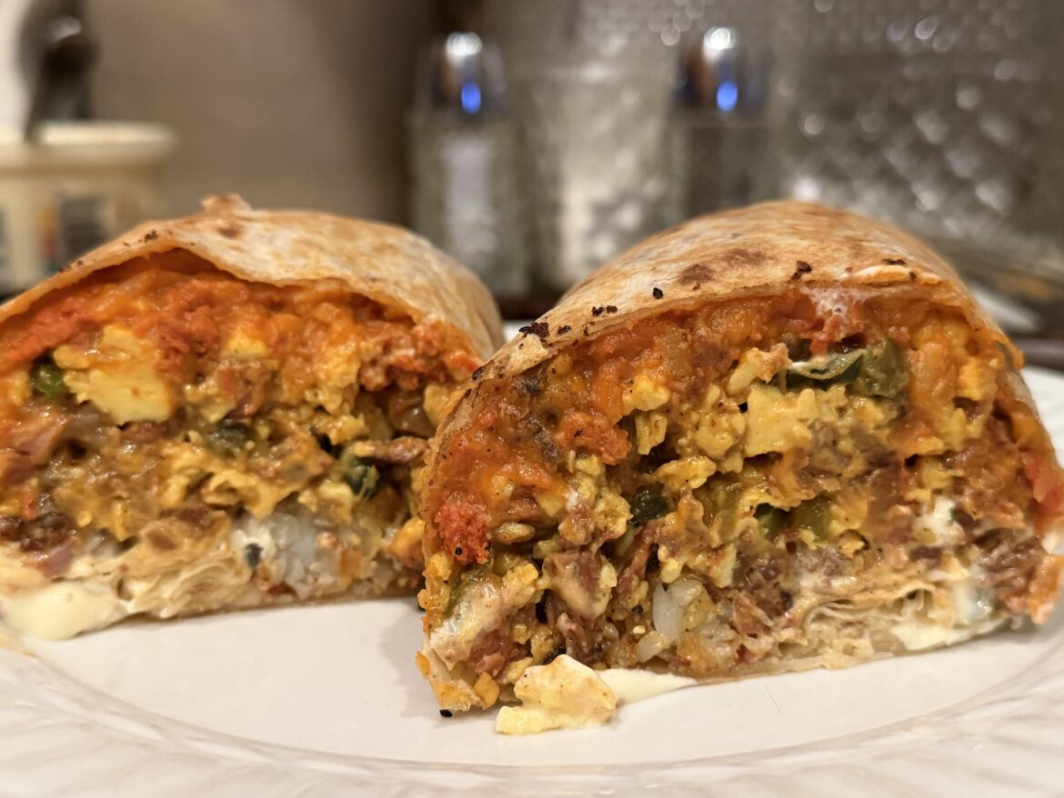 Breakfast Burritos for dinner, Ingredients: tater tots,chorizo refried beans, carne asada, chorizo links, poblano peppers,onions,green bell pepper, crema, and cheddar. Wrapped tight and toasted on all sides till golden brown. Lots of habanero hot sauce.