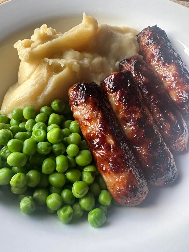 Sausage, mash, peas and lashings of onion gravy.