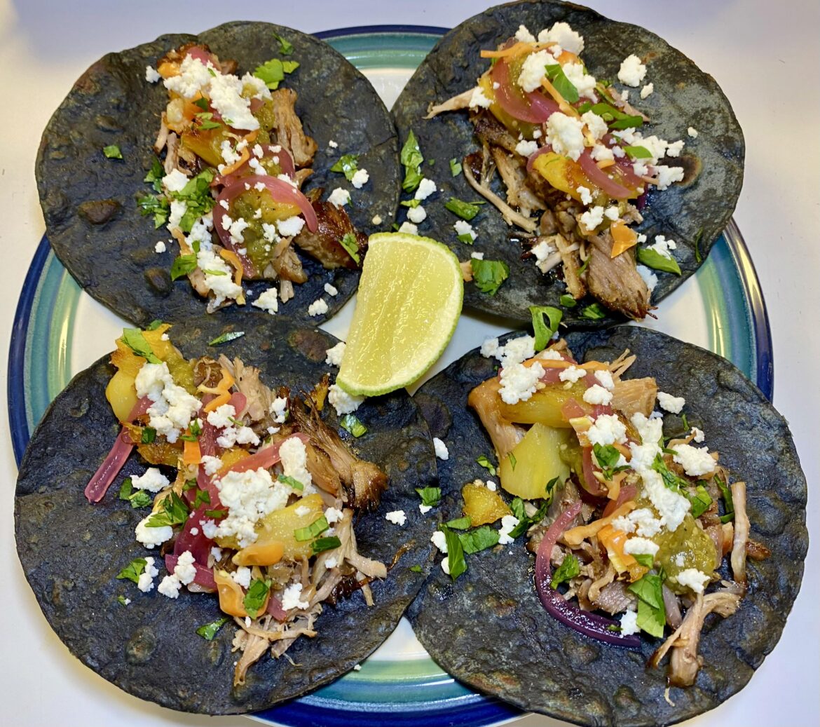 Carnitas, roasted pineapple, tomatillo salsa, pickled onions, habenero, queso fresco, and cilantro on blue corn tortillas