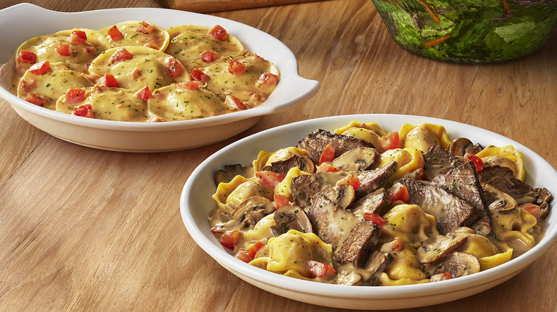 the Braised Beef Tortelloni and Ravioli di Portobello in white dishes on a table at Olive Garden
