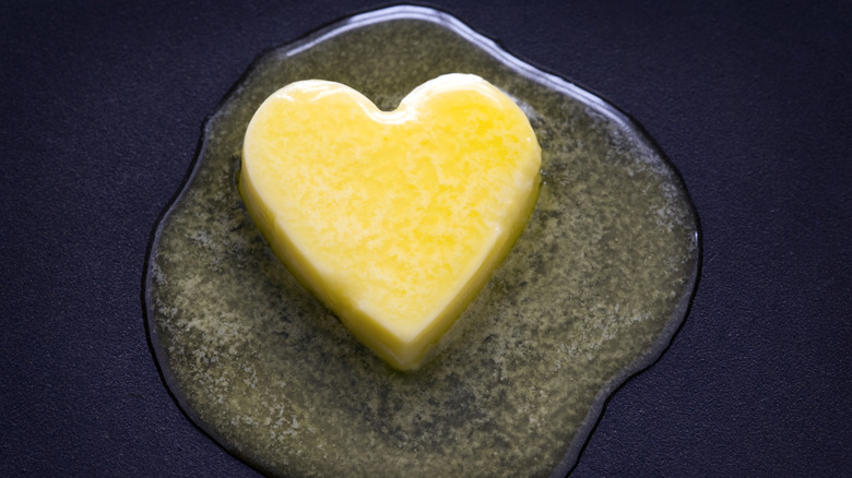 a heart shaped butter pat melting on a non-stick surface