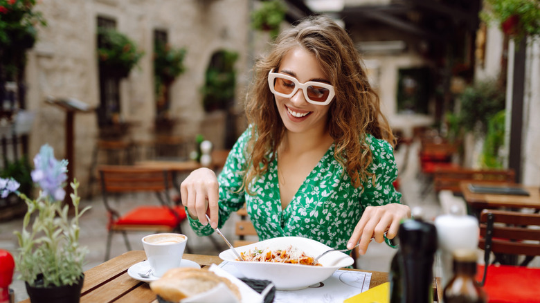 Smiling woman eating pasta at an Italian restaurant