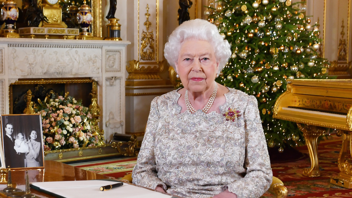 Queen Elizabeth sitting in front of a lit Christmas tree