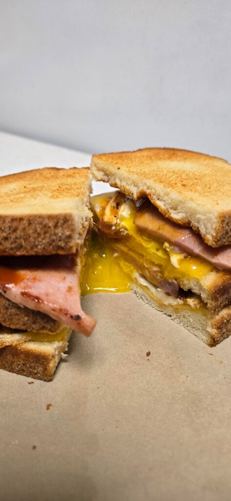 Triple Decker Sandwich. Two Eggs, Ham and Cheese. And a few splashes of Valentina Hot Sauce.