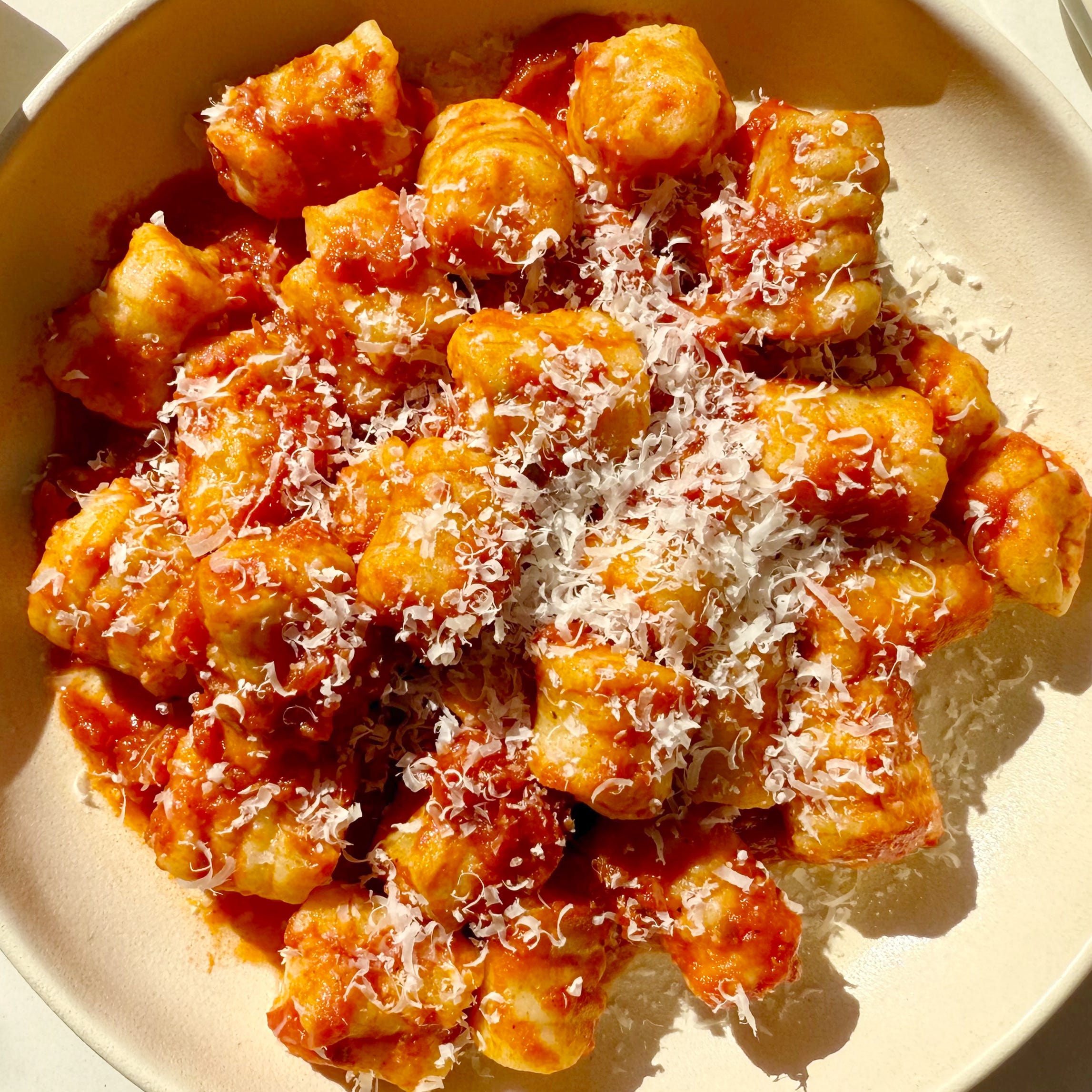 mashed potato gnocchi tossed in red sauce and topped with parmesan