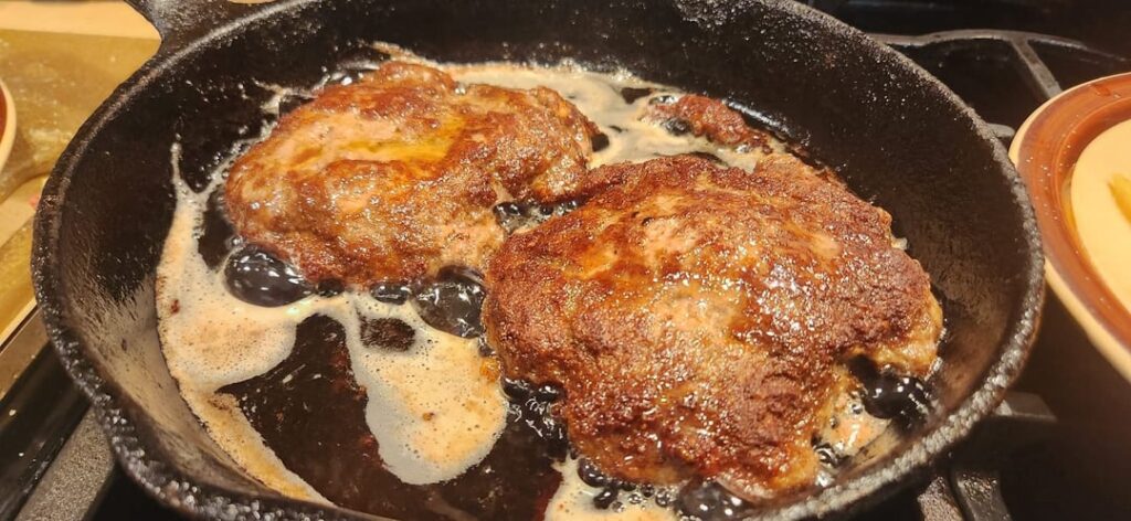 Cast iron fried cheeseburgers in leftover bacon grease