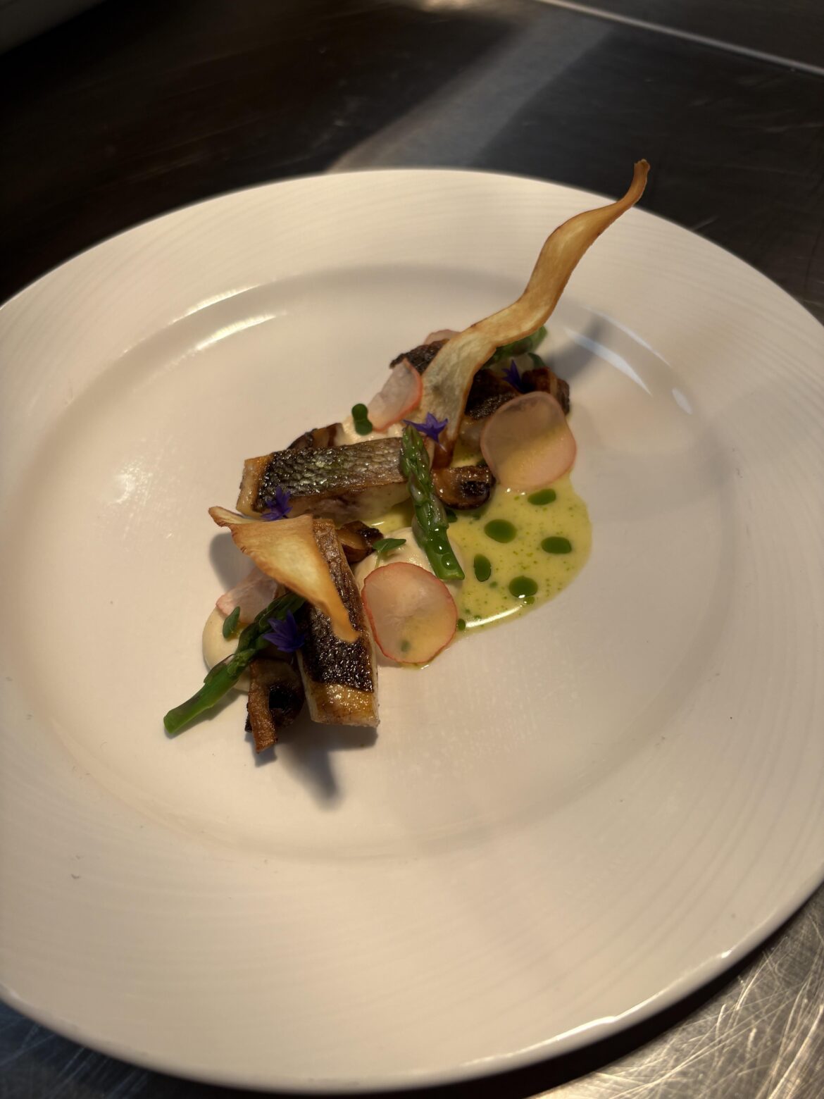 Pan fried sea bass with pickled radish, asparagus spears and fried mushrooms. Served with parsnip purée ,parsnips crisps and beurre blanc