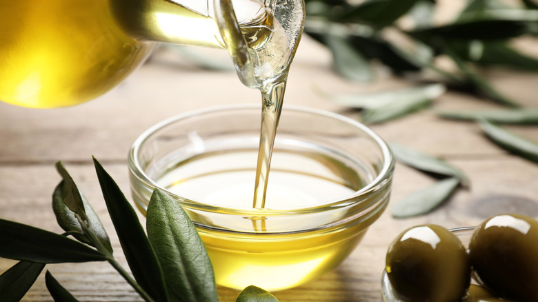 olive oil being poured into small glass bowl