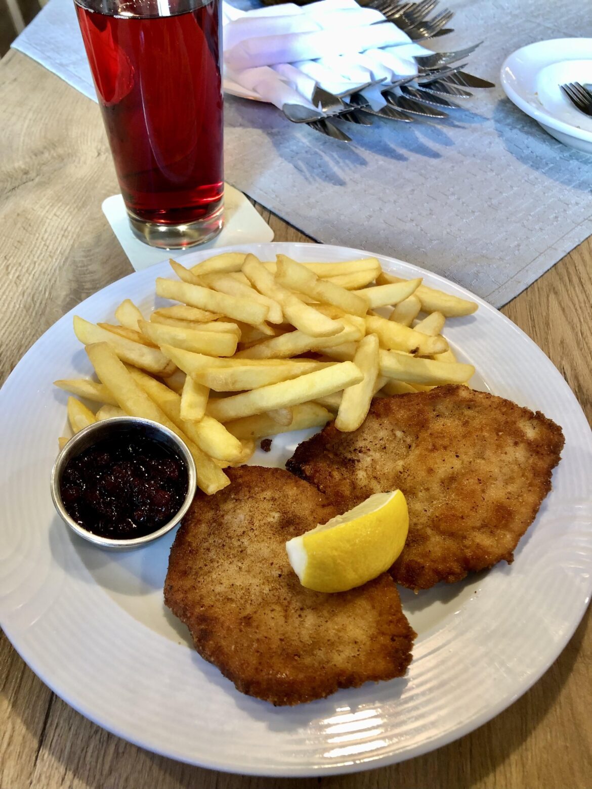 Schnitzel Wiener Art with cranberries and French fries