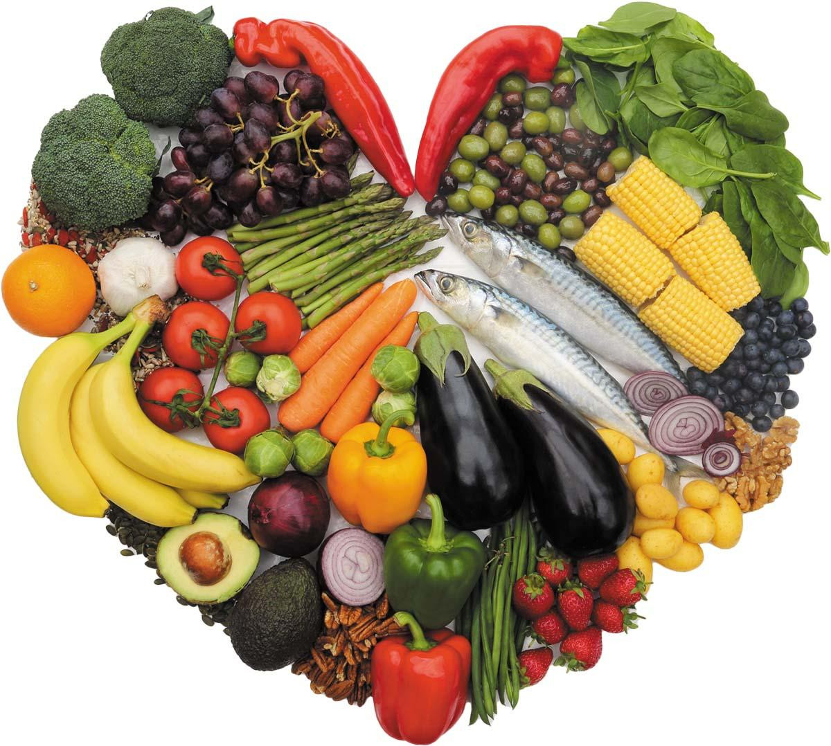 Fresh fruits, vegetables, fish, and nuts arranged in the shape of a heart.