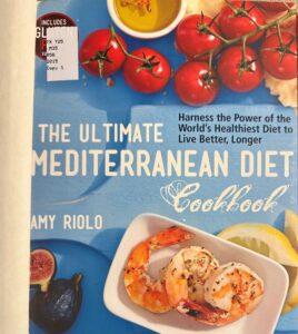 Book cover with titles in white against a turquoise background and photographs of cherry tomatoes, a small bowl of olive oil, fresh figs, and a small plate of shrimp with lemon quarters