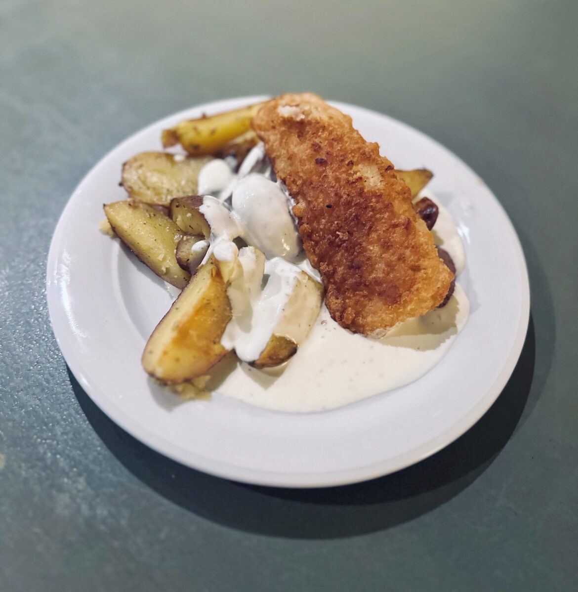 Cod in batter, oven baked potatoes and warm sauce