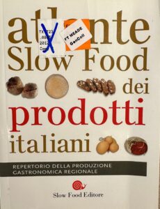 Soft yellow book cover with large-font titles in red and gold ink and images of examples of typical regional Italian foods