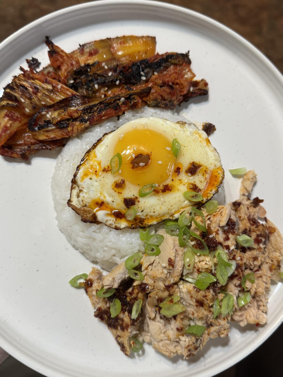After gym lunch: Tinned salmon, grilled kimchi, rice & a fried egg. Homemade chili oil.