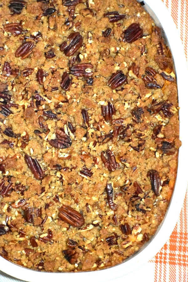 white baking dish with cooked sweet potato casserole topped with browned pecan steusel