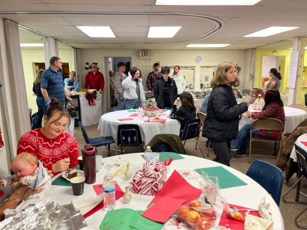 Diners mingle in the basement of First United Church of Christ toward the end of the community dinner. (MITCH HOTTS -- THE MACOMB DAILY)