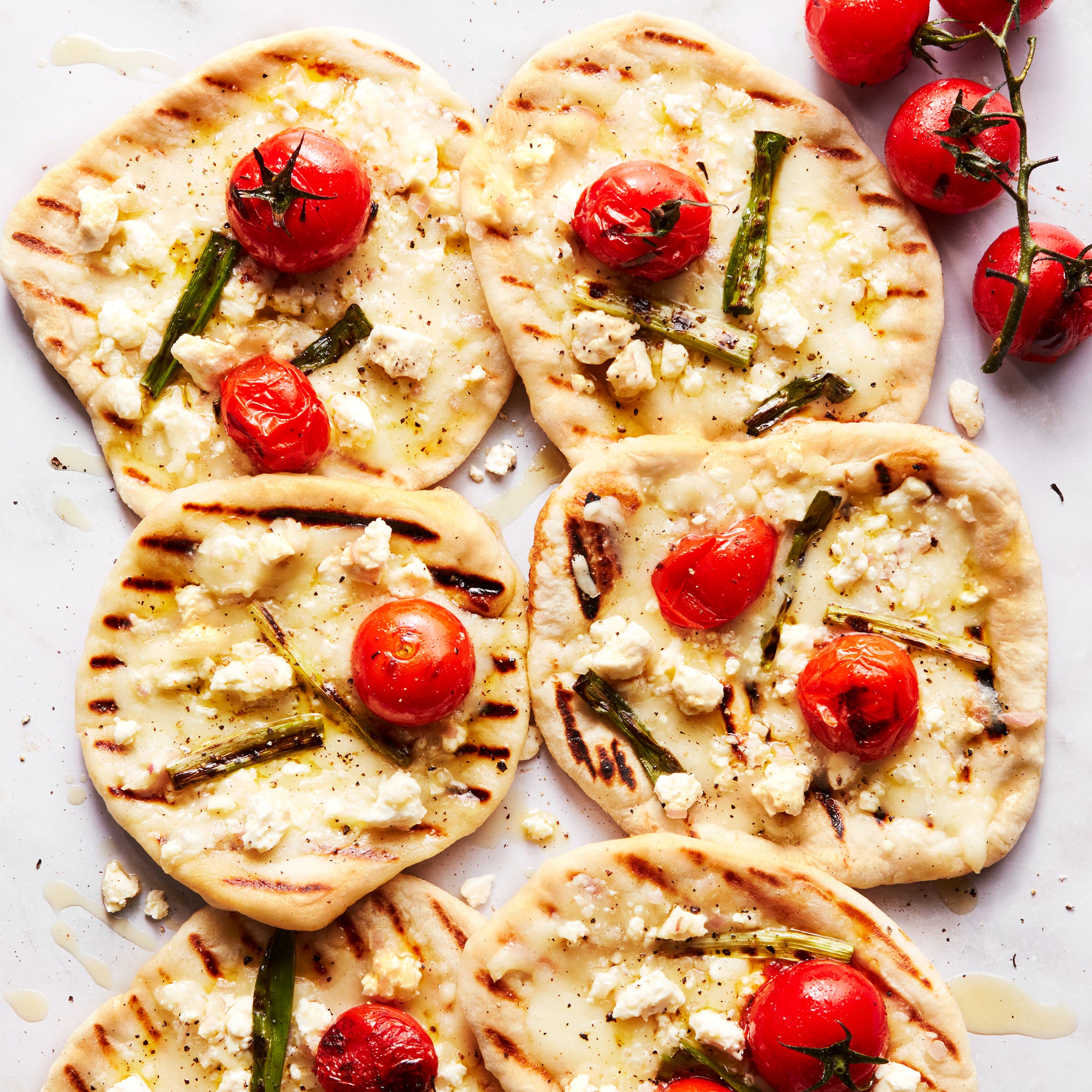 grilled tomato feta pizzettes with scallions and mozzaraella