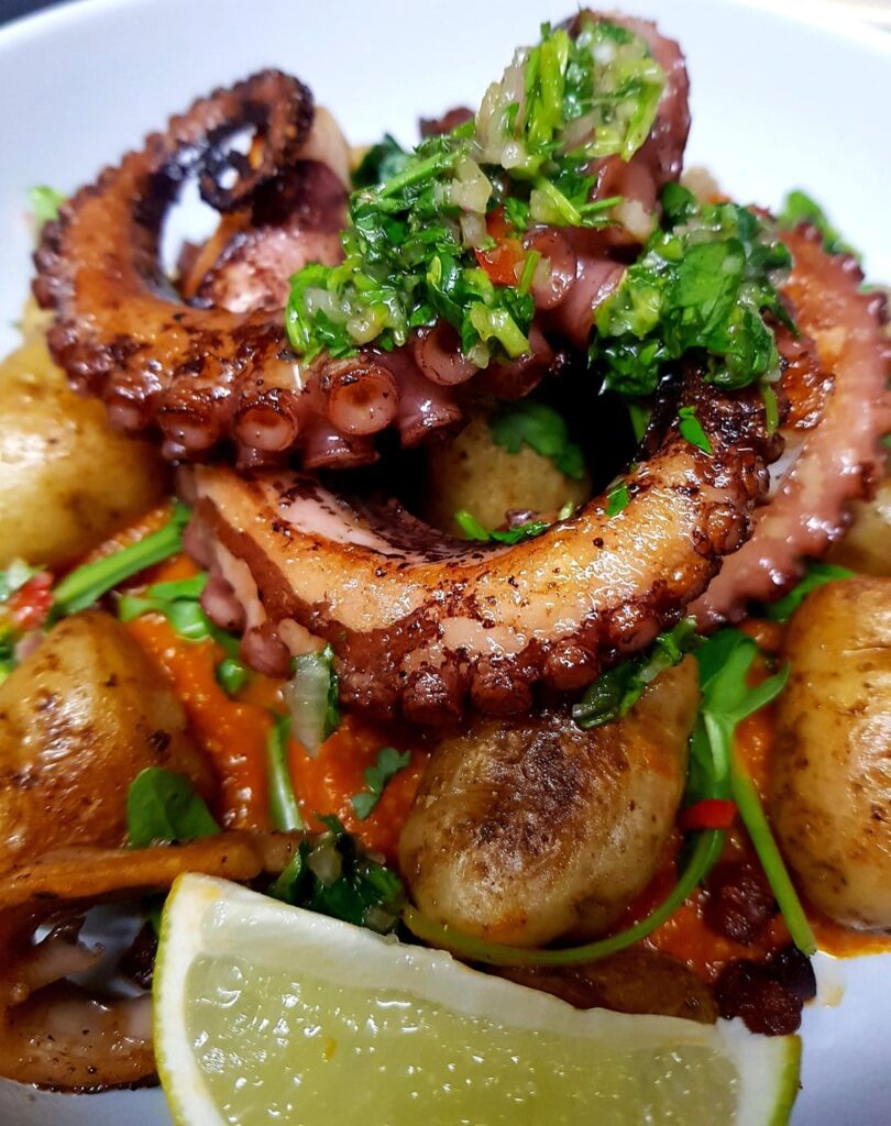 Grilled Octopus, Spicy Romesco Sauce, Fingerling Potatoes, Crispy Chorizo, Rocket and Fresh Herb Chimichurri. A Squeeze of Lime to Finish.