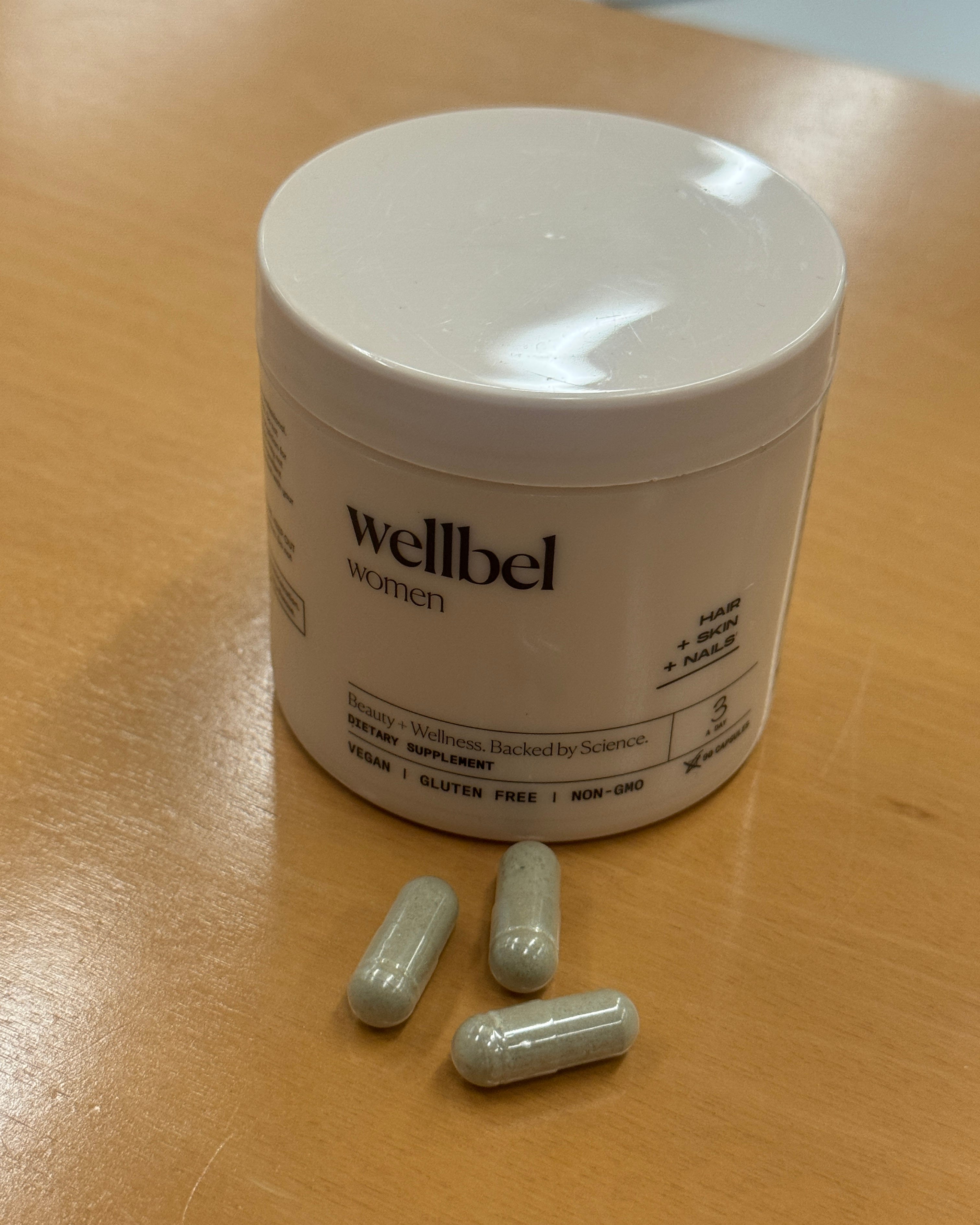 container of dietary supplement with capsules nearby
