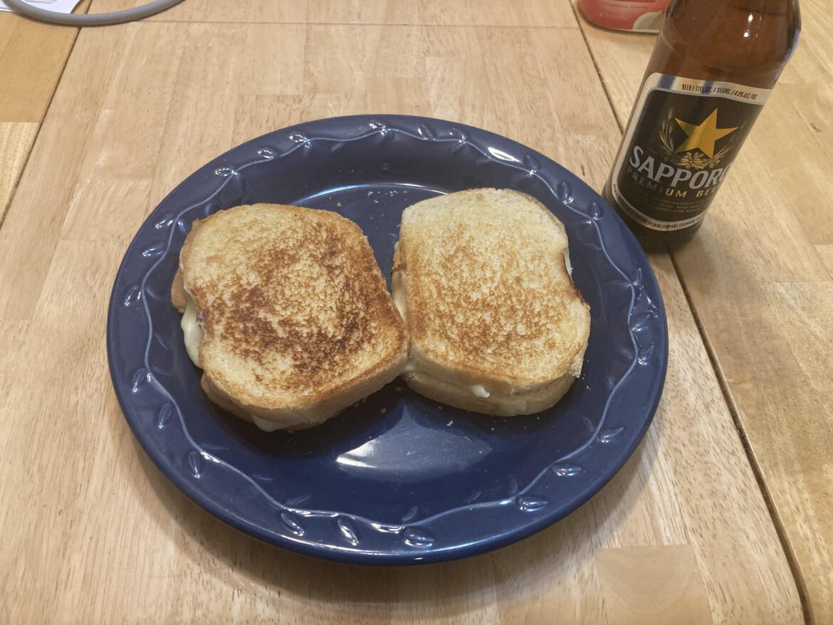 Had extra shredded cheddar lying around, threw it on to a typical American cheese grilled cheese. Paired with a cold beer