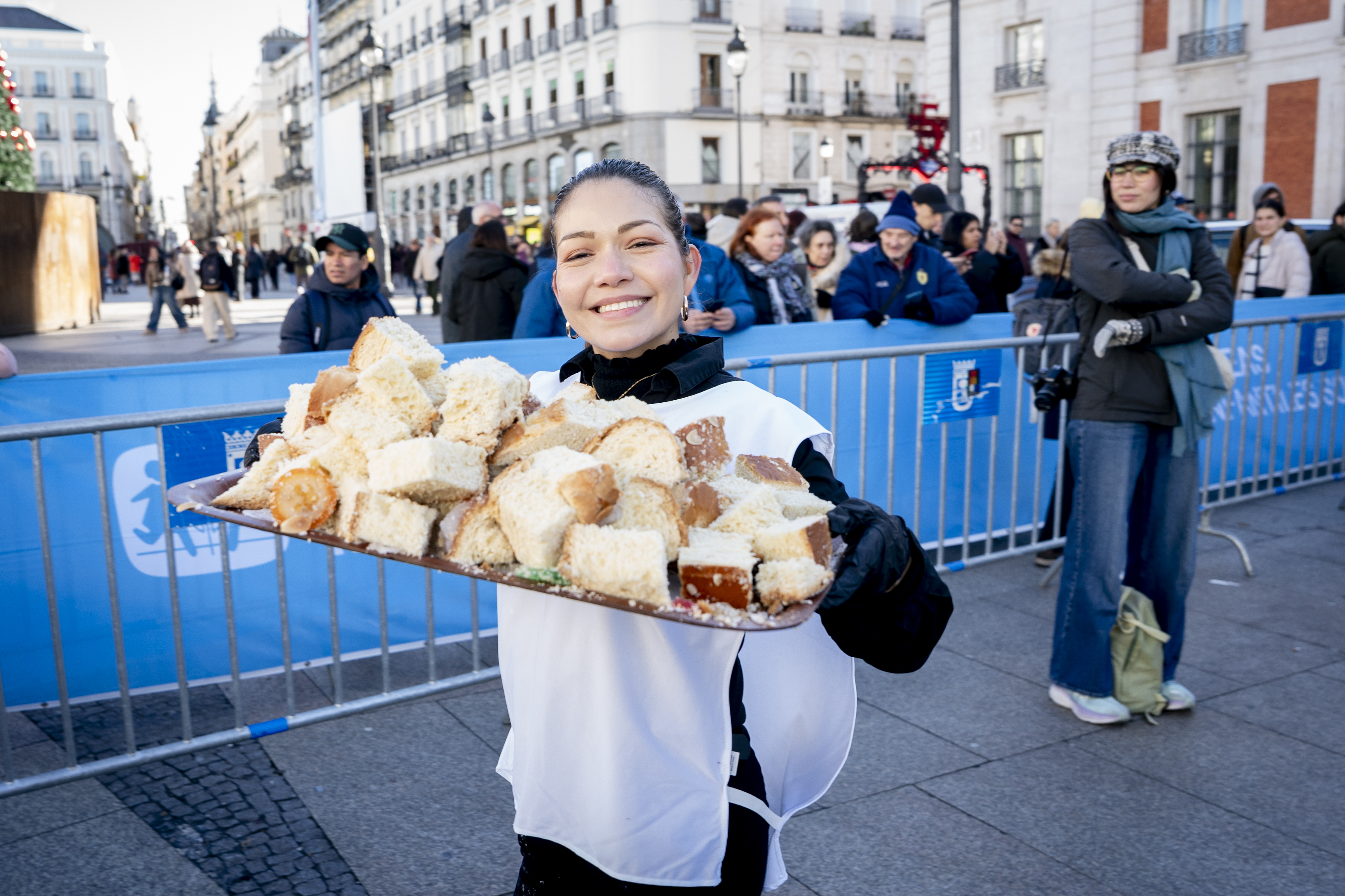 A volunteer distributing Roscón de Reyes at Puerta del Sol.