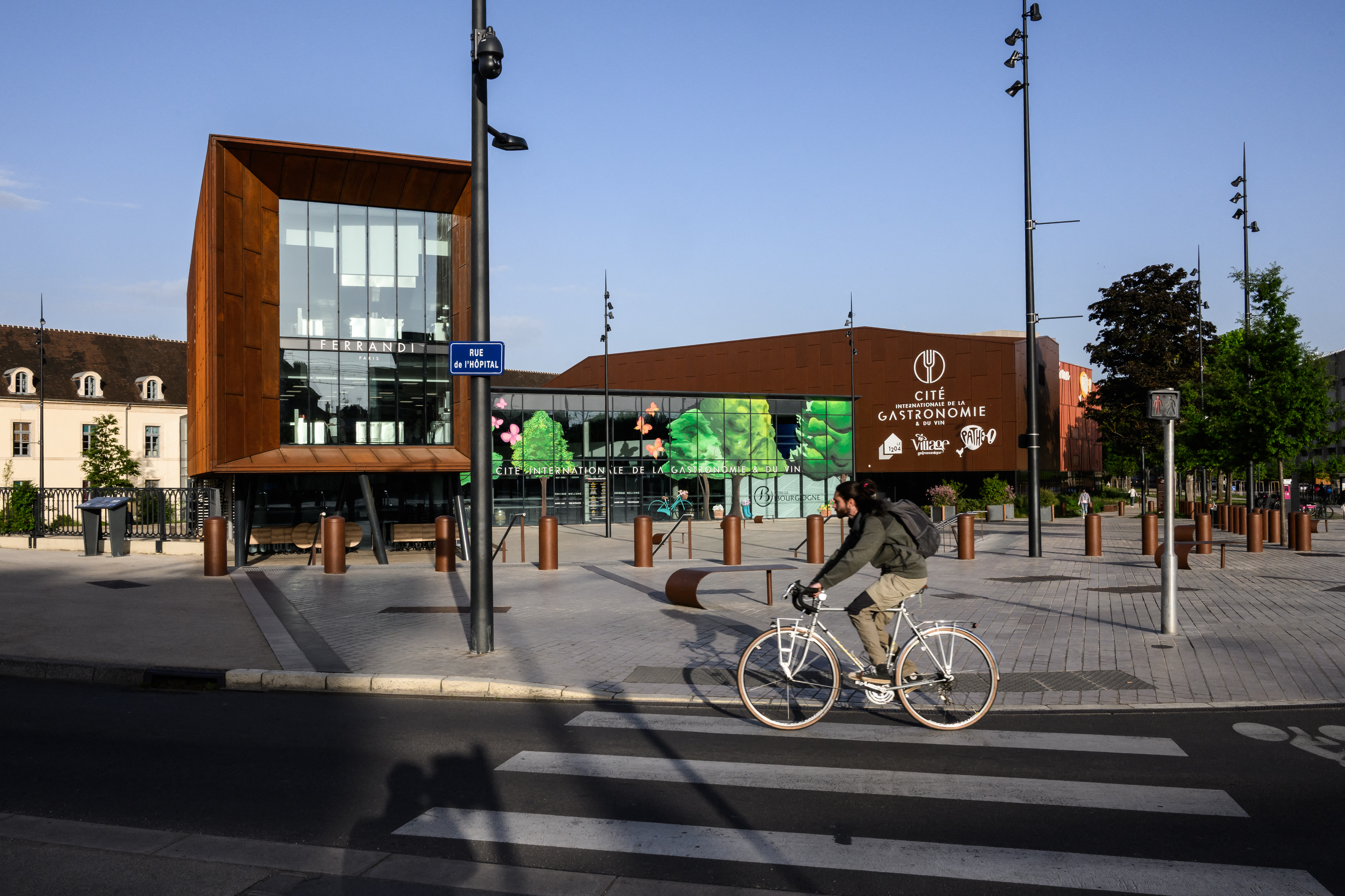 Cyclist riding past the Cité Internationale de la Gastronomie et du Vin in Dijon, France.