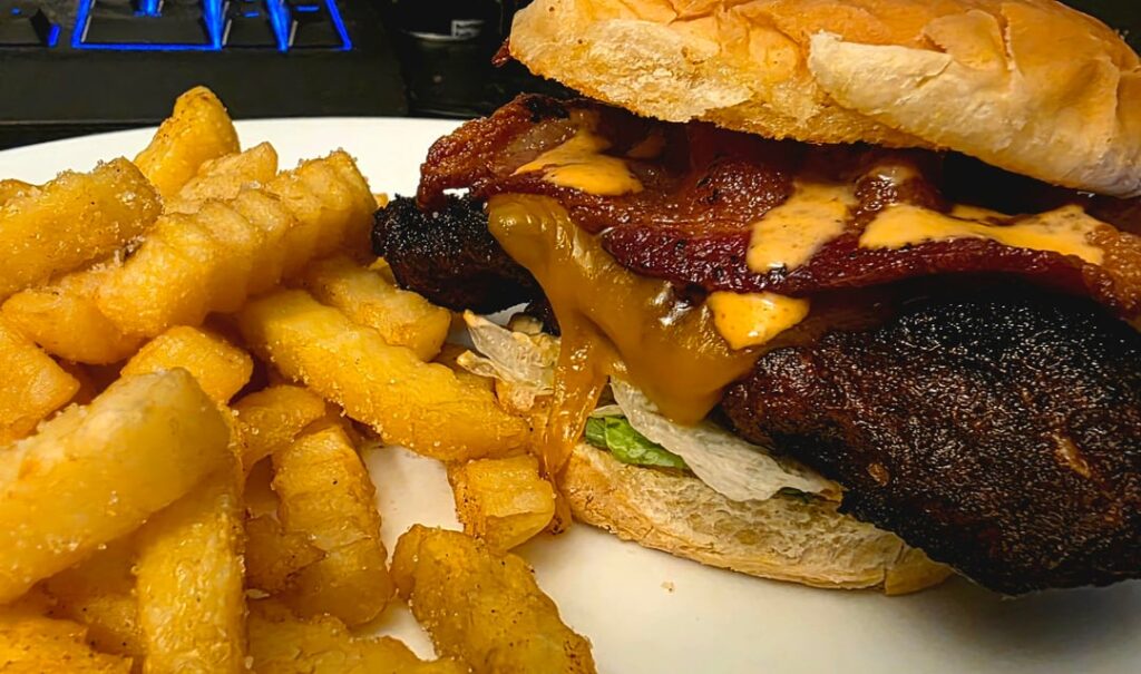 Jerk chicken breast sandwich with cheddar, bacon, and creamy sriracha sauce