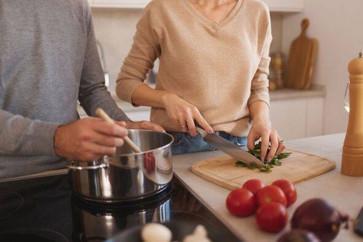 Couple cooking together preparing healthy meal in kitchen