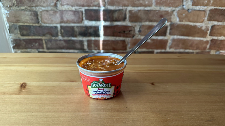 Mini Spaghetti Rings and Meatballs with spoon on wooden table