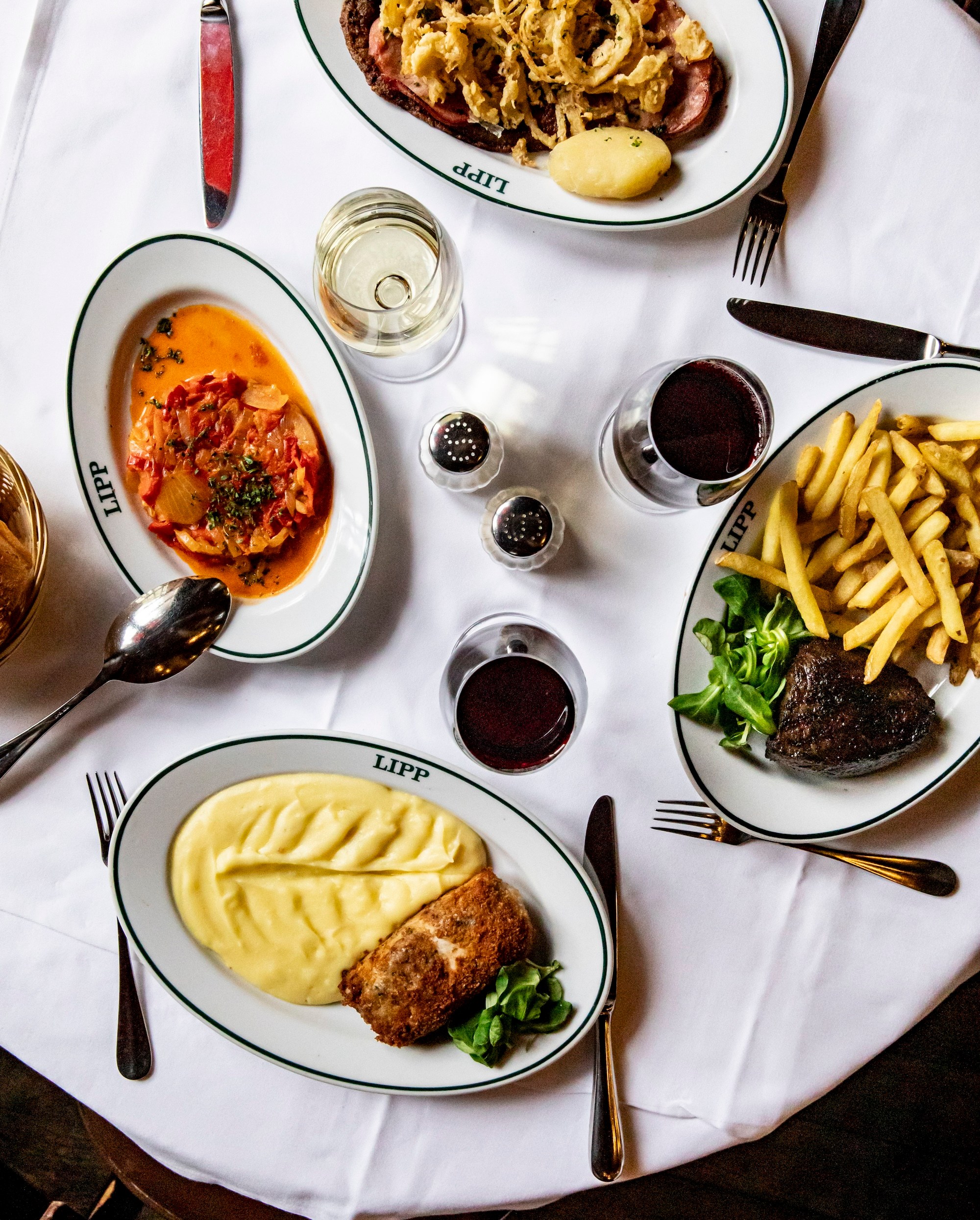 A top-down view of a table full of French dishes.