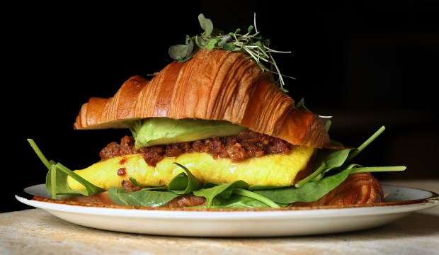 The breakfast croissant with cheddar eggs, bacon jam, avocado, tomato confit, spinach, and spicy mayo is shown at Cafe Bastille in the Weston Town Center, Thursday, Jan. 15, 2026. (Mike Stocker/South Florida Sun Sentinel)