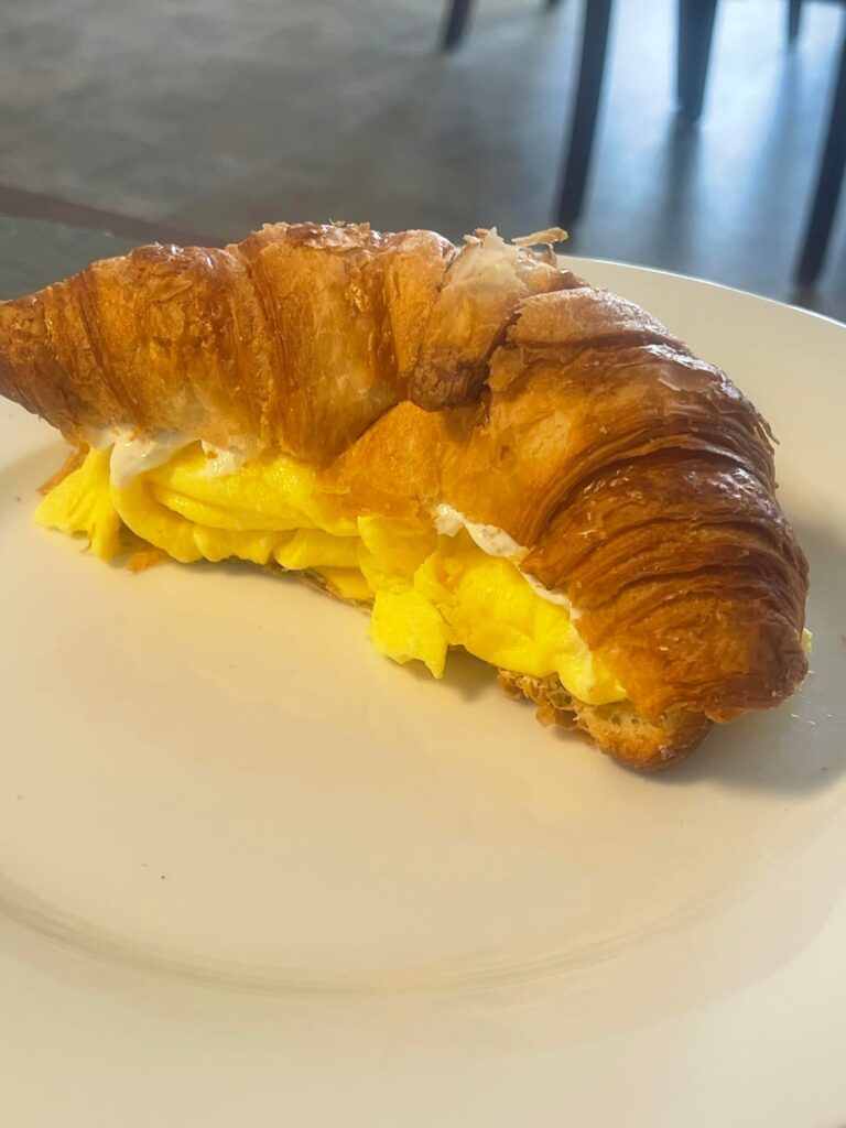 Eggs on croissant schmeared w/garlic chive cream cheese and Gouda