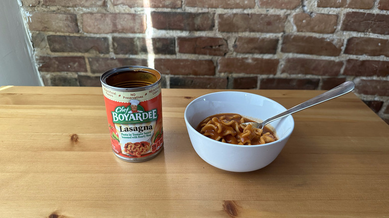 Lasagna with spoon on wooden table