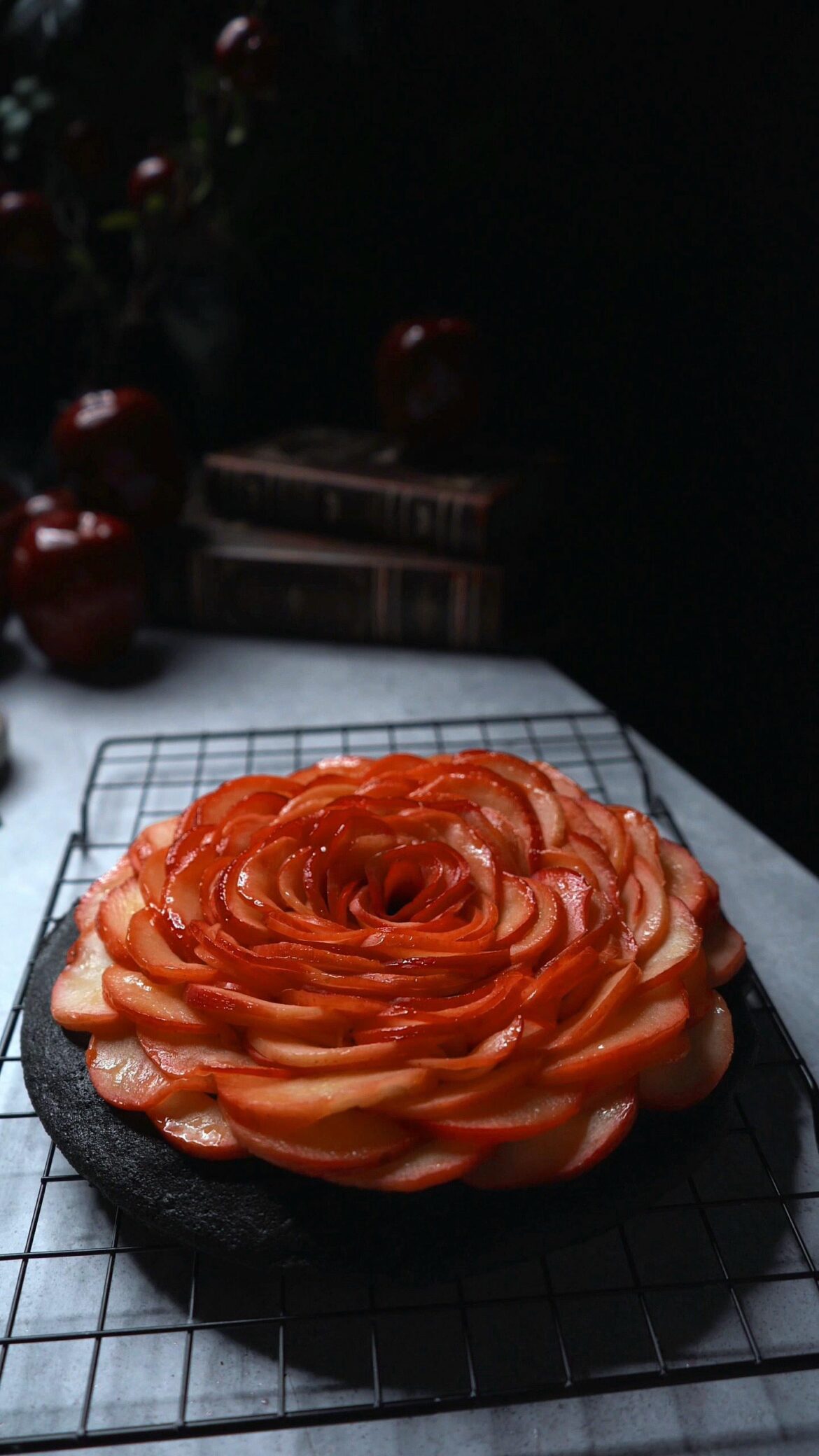 Apple Rose Cake. Red apples on black poppy seed cake