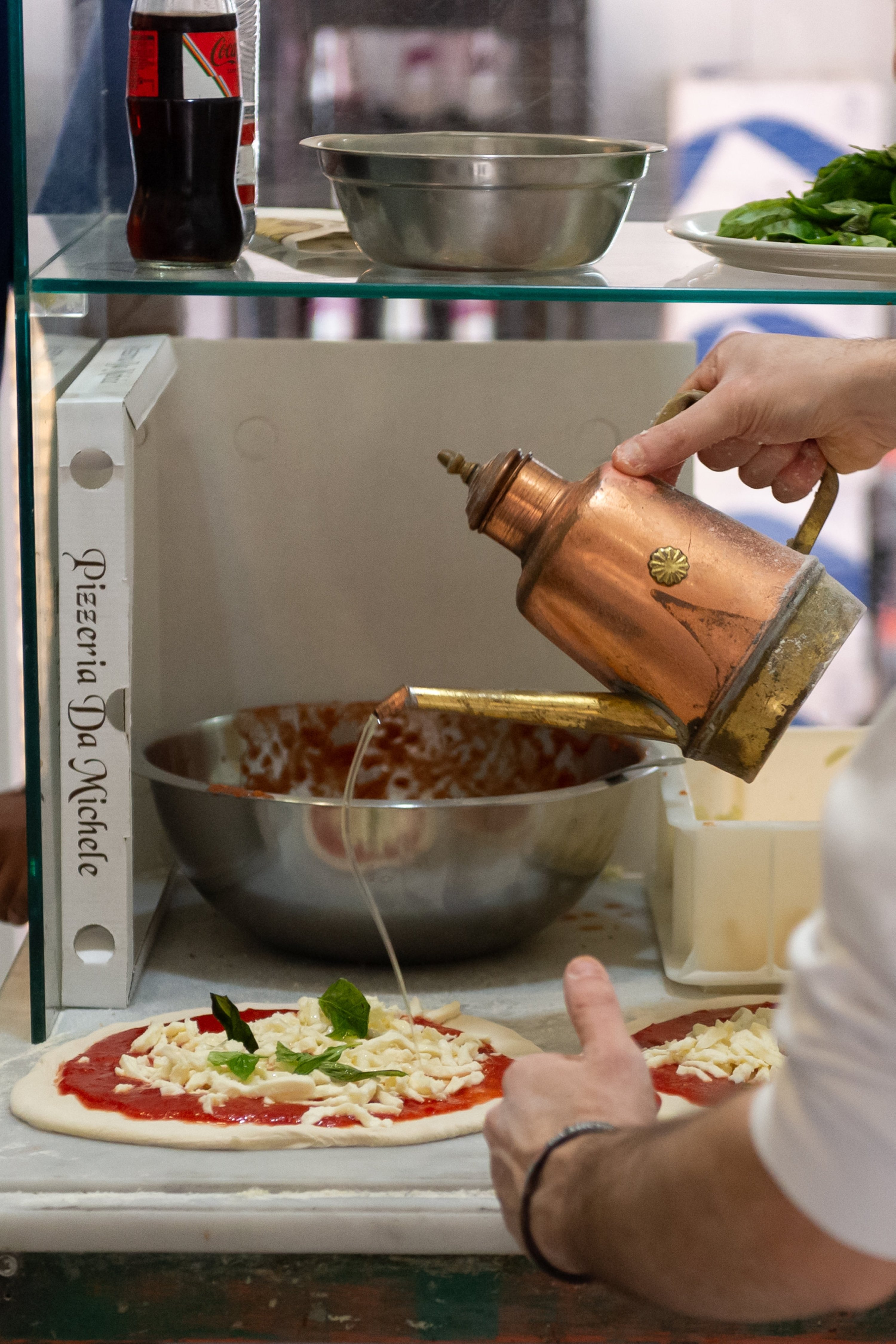 A chef pours olive oil onto a pizza during preparation, Rome, Italy, Jan. 13, 2025. (AA Photo)