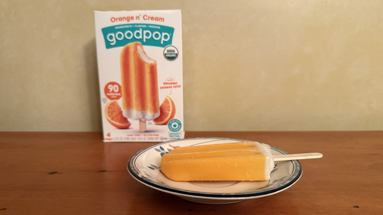 Orange n' cream pop on plate in front of box
