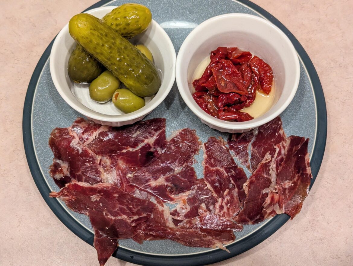 Carved Monte Nevado Spanish Jamón Ibérico de Bellota (aged 48 months minimum) w/ Spanish Queen olives, a zesty pickle & sun dried tomatoes in oil [OC]