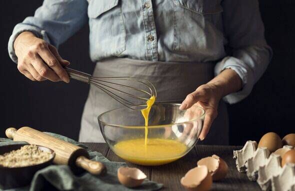 Hands of man whisking bowl of eggs