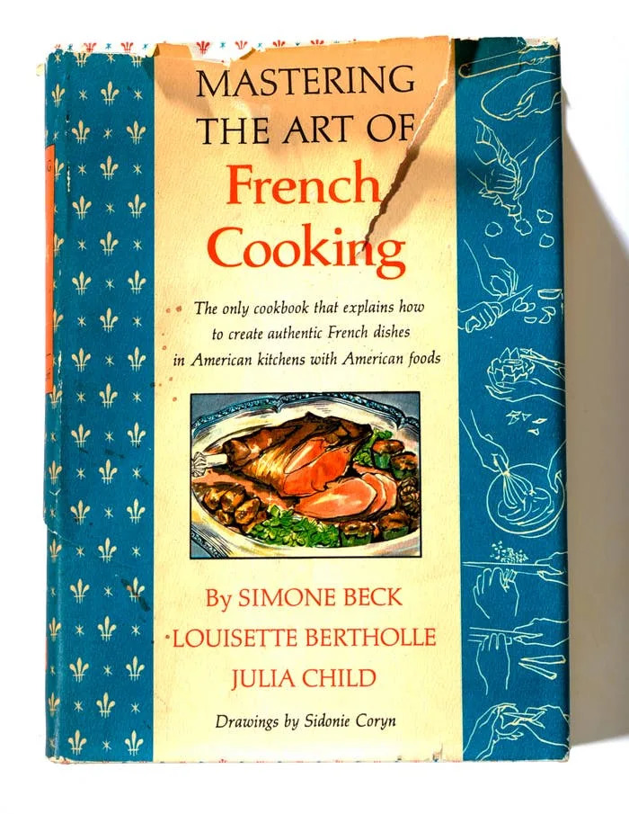 Cover of "Mastering the Art of French Cooking" by Simone Beck, Louisette Bertholle, and Julia Child, featuring an illustrated French dish