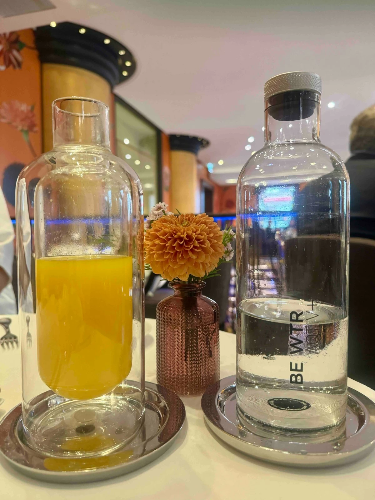 CITRUS SIP  Fresh orange juice presented in a double-walled glass bottle with biodegradable sugarcane straws.